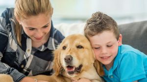 siblings hugging their dog