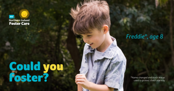 young boy with brown hair playing outside